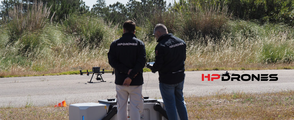 Dois funcionários pôem um drone da HP Drones a funcionar.